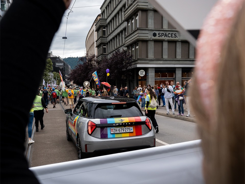 MINI mit Regenbogen Rückansicht in Umzug MINI mit Regenbogen Rückansicht in Umzug